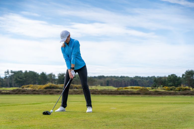 Female golfer using driver on the tee