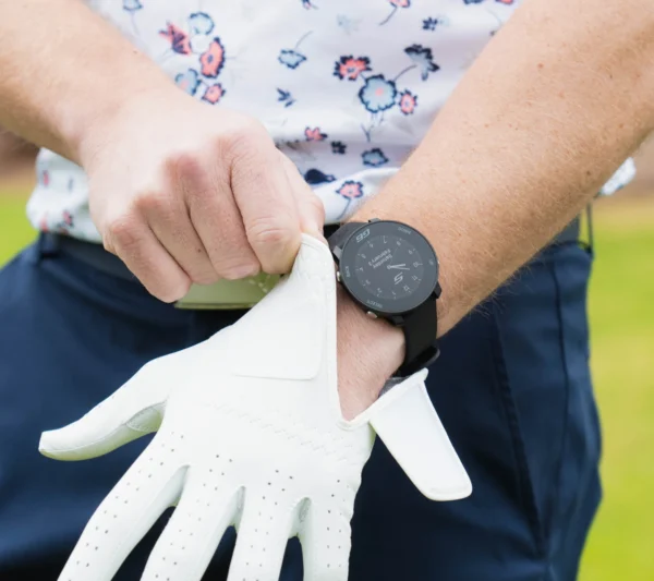 Golfer putting on glove with G6 on wrist
