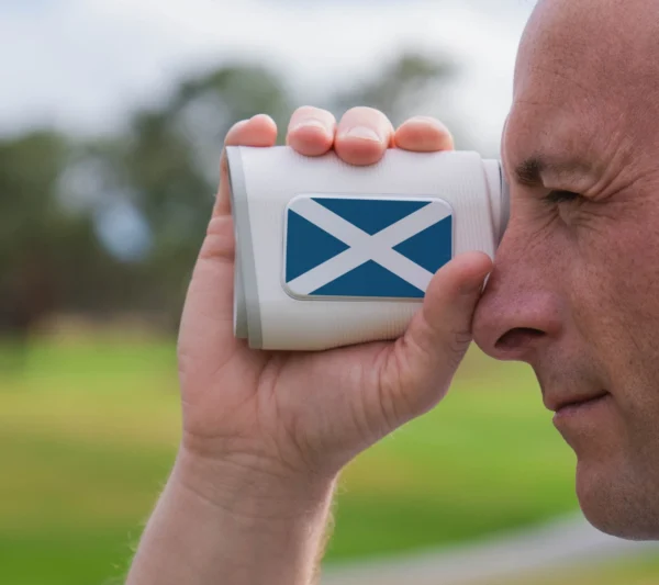 Golfer looking through PRO X rangefinder with Scotland flag plate