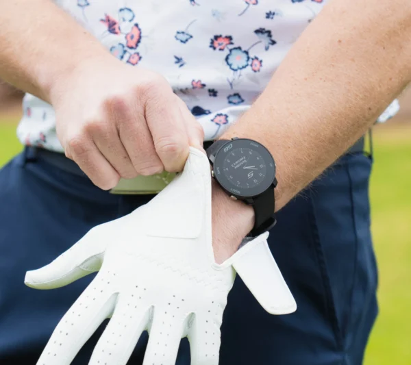 Golfer putting on glove with G6 on wrist